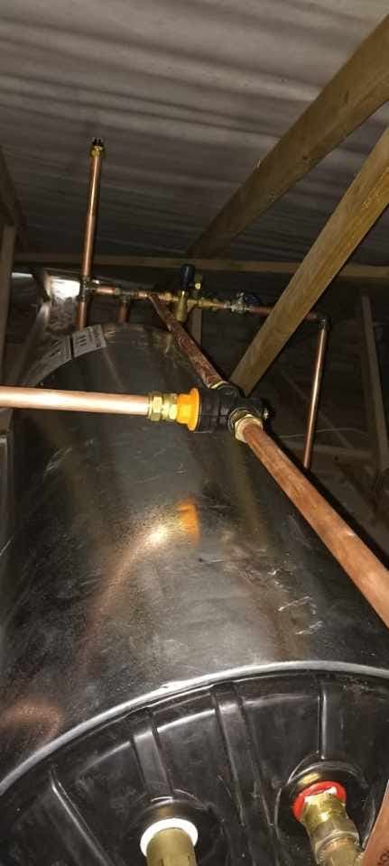 Horizontal geyser installed in a roof space with copper pipework