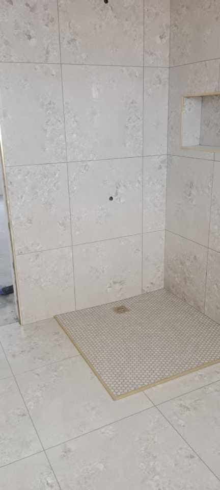 Finished walk-in shower with large-format tiles and mosaic floor
