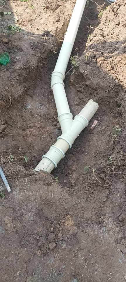 PVC drainage pipes and a Y-junction in an open trench